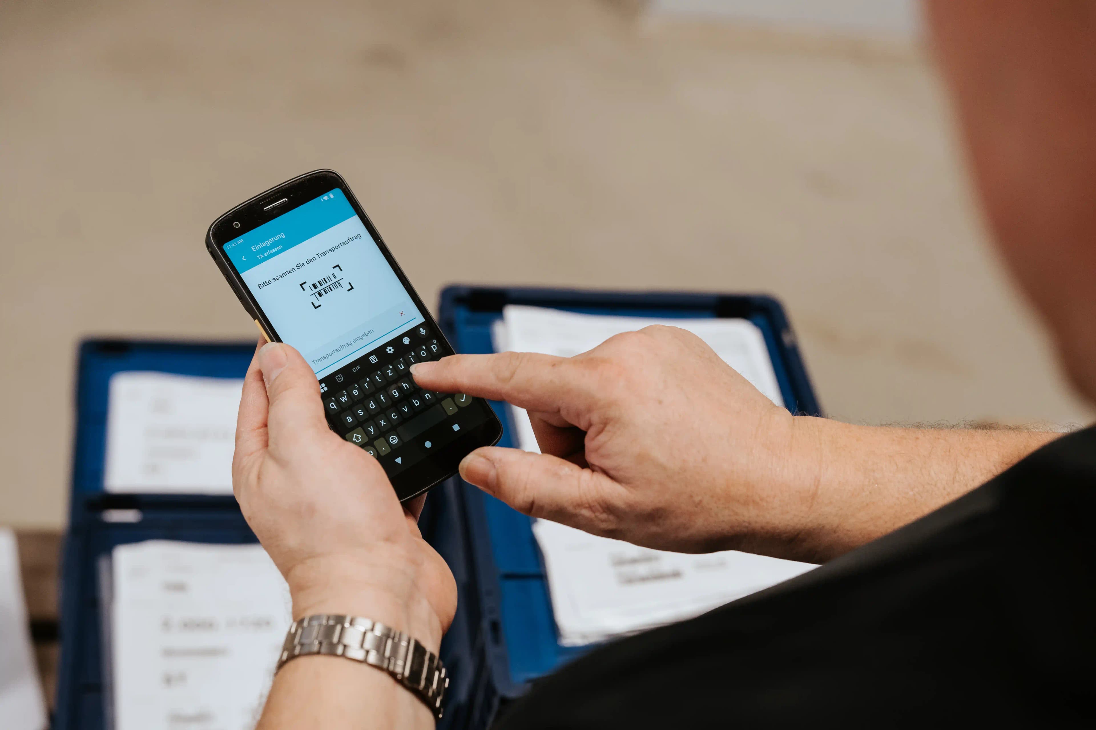 Warehouse operative using the Ontego scanner app on a handheld device to scan a transfer order.