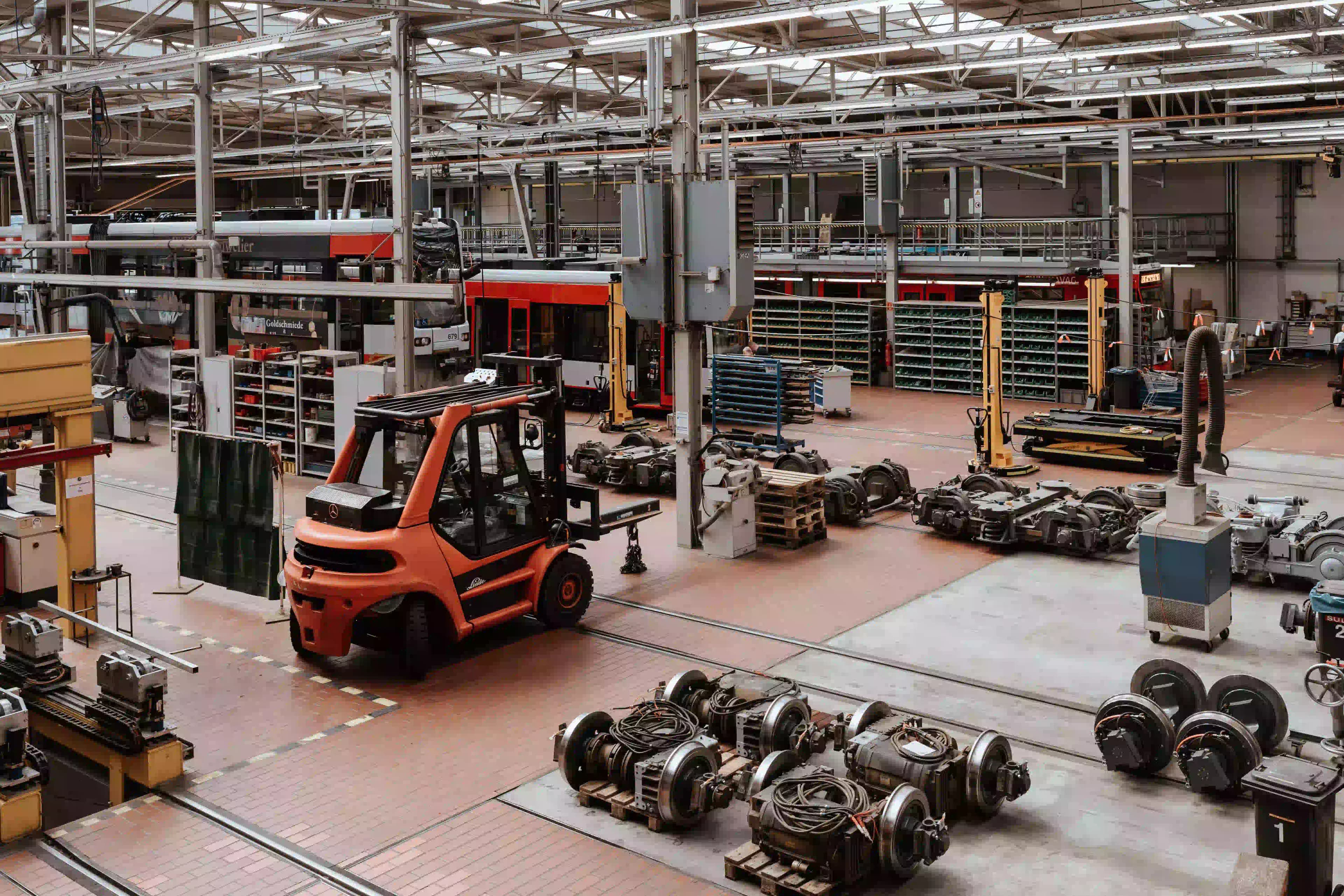 Interior view of the HAVAG vehicle maintenance workshop in Halle, showing a Linde forklift on the workshop floor surrounded by tram wheel sets, mechanical components, and organized parts shelving units.
